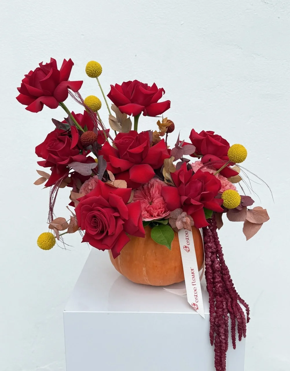 Fall flower arrangement in a pumpkin with roses and eucalyptus
