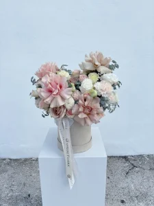 hat box flowers in pastel hues with roses carnations lisianthus and eucalyptus